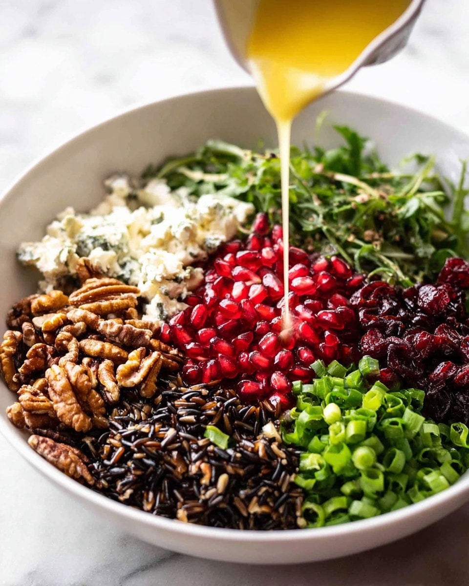 In a white bowl on a white marbled surface, there are six different layers arranged side by side. Starting from the bottom left, there is a layer of dark wild rice with a rough texture, next to it is a bright red layer of pomegranate seeds with a shiny, juicy look. To the right, a layer of green chopped scallions shows a fresh and crisp texture. Above the rice is a bunch of green leafy watercress with fluffy white cheese sprinkled on top. Next to the watercress is a pile of roughly chopped brown nuts with a rough, crunchy look, and to their right, there is a dark layer of dried cranberries. A yellow sauce is being poured gently over the cheese in the center of the bowl. Photo taken with an iphone --ar 4:5 --v 7