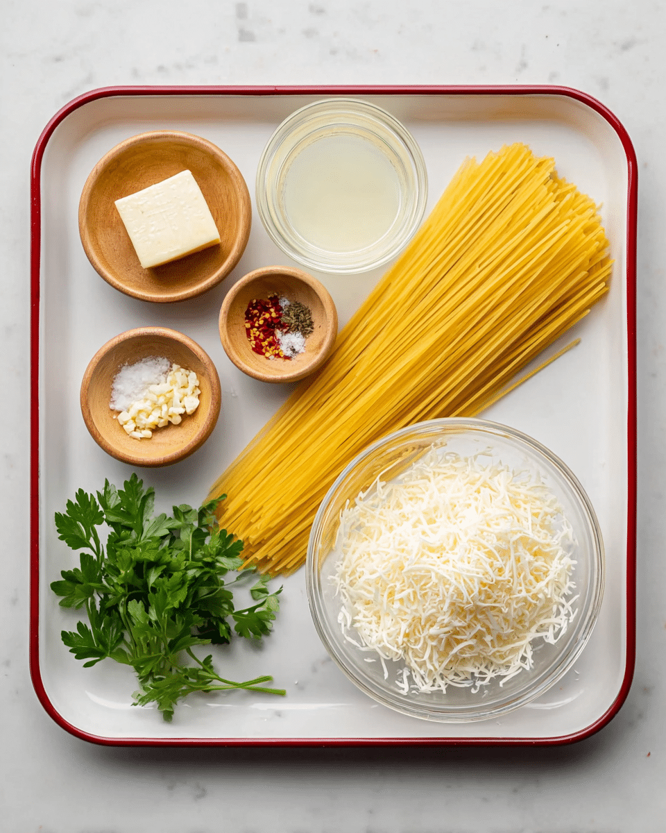 A white tray with a red rim holds several ingredients neatly arranged on a white marbled surface. In the center-right, a bunch of uncooked yellow spaghetti lies flat, with a clear glass bowl of finely shredded white cheese placed near the bottom right corner. Above the cheese, there are two small clear glasses, one filled with a pale yellow liquid and the other with a white frothy liquid. On the left side, there are three small light wooden bowls: the top one contains a square block of light butter, the middle one holds minced garlic and red chili flakes, and the bottom one contains salt and black pepper. A small bunch of fresh green parsley rests in the bottom left corner. Photo taken with an iphone --ar 4:5 --v 7