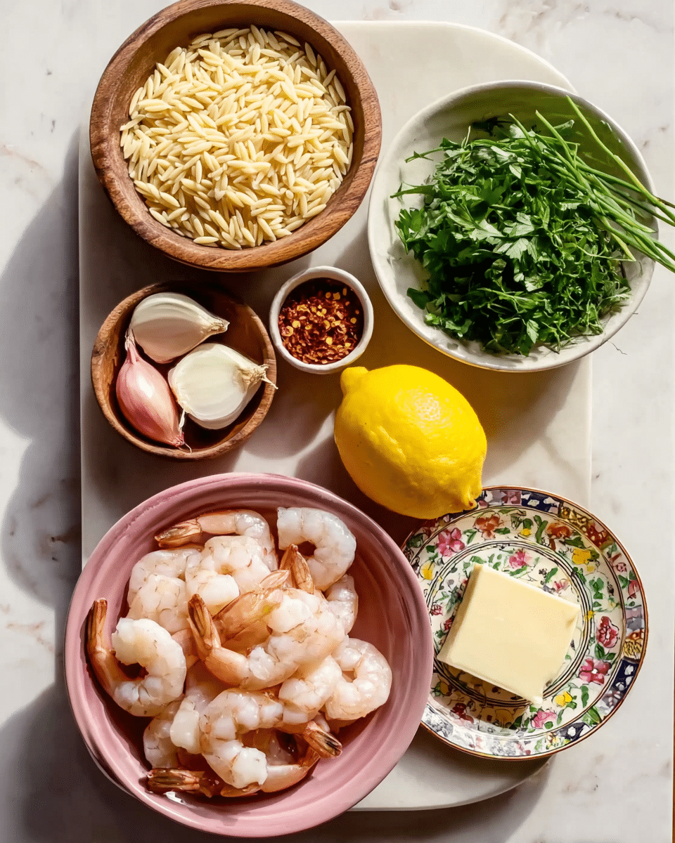The image shows several bowls and plates arranged on a white marbled surface. At the center bottom, there is a pink bowl filled with raw shrimp, light pink and semi-translucent. Above it to the right is a small round white bowl filled with uncooked orzo pasta, pale yellow and smooth. Next to the orzo is a tiny white bowl containing red chili flakes. To the top right, a white bowl is filled with fresh green herbs, including parsley and chives, with textured leafy and thin stalks. In the middle left, there is a wooden bowl holding two peeled shallots, light pink and smooth. Above that is a white plate with colorful floral patterns containing a square stick of butter, pale yellow and smooth, and a small round bowl of peeled garlic cloves, creamy white and smooth. A bright yellow lemon sits between the shallots and the herbs. The photo taken with an iphone --ar 4:5 --v 7