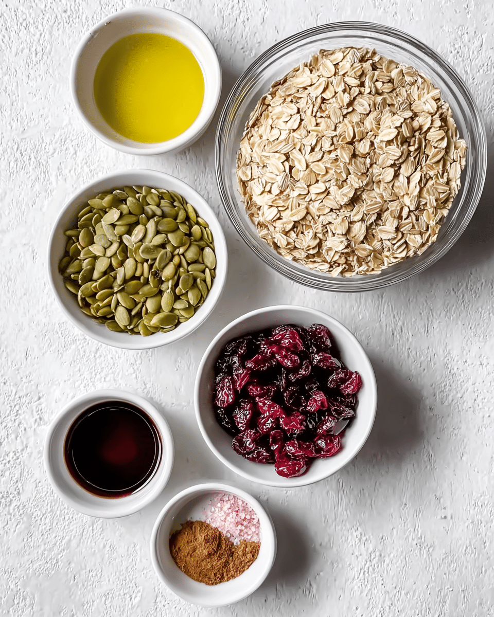 The image shows six bowls arranged on a white marbled textured surface. In the top right, there is a large clear glass bowl filled with light beige rolled oats, showing a slightly rough texture. To its left is a smaller white bowl filled with green pumpkin seeds that have a smooth, flat texture. Below the pumpkin seeds, another white bowl contains dark red dried cranberries that look wrinkled and glossy. On the top left, there is a small cup with golden yellow oil, smooth and shiny. Next to it, below and slightly left, is a small cup filled with thick dark syrup with a shiny surface. In the bottom right, a small white bowl holds a small mix of light brown cinnamon powder and pink salt, each separated but close together. The bowls and cups are placed neatly and viewed from the top. Photo taken with an iphone --ar 4:5 --v 7