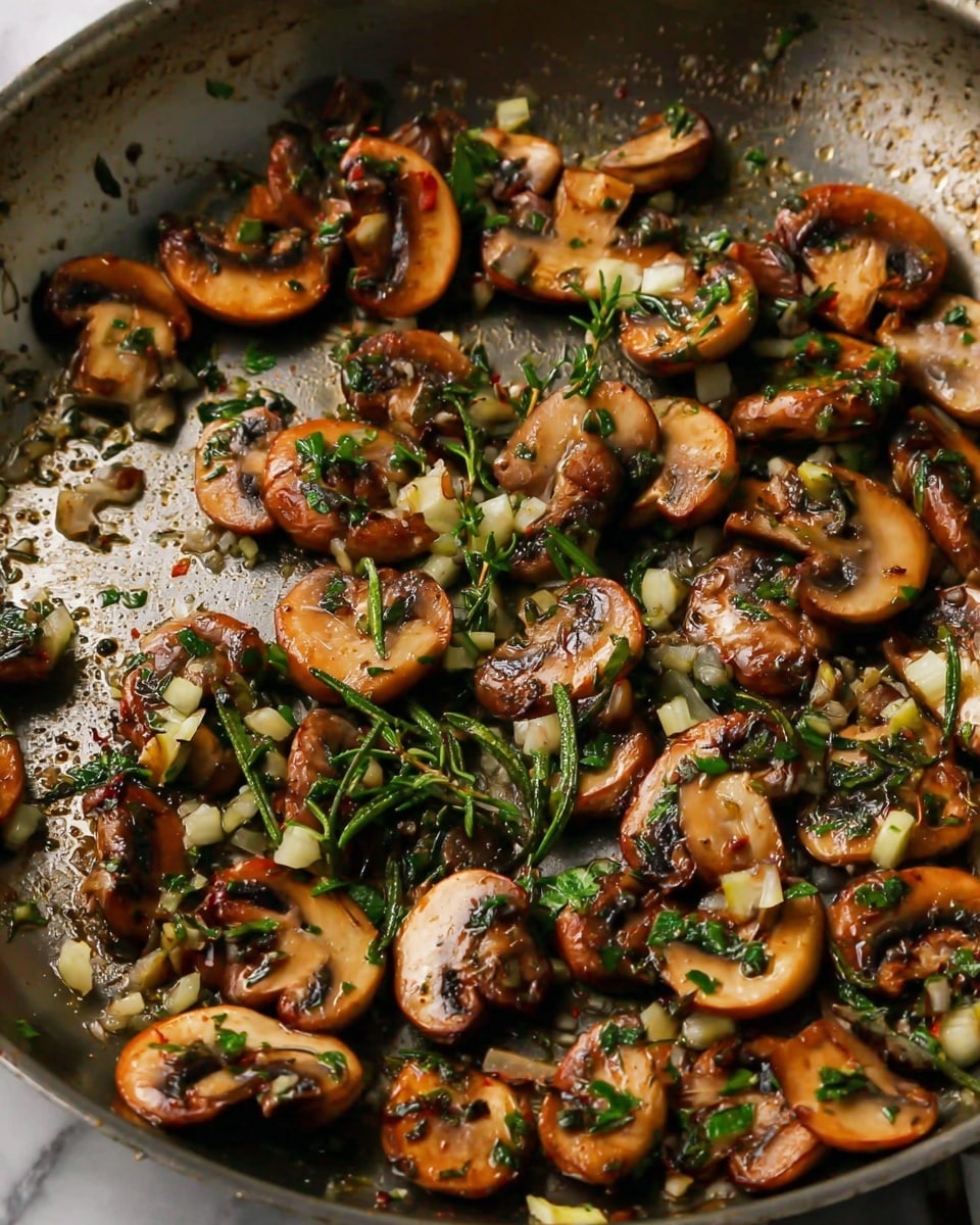 A close-up view of a frying pan filled with sliced mushrooms that are browned and cooked, showing a mix of light and dark brown colors. The mushrooms are scattered unevenly in the pan, mixed with small chopped pieces of garlic and fresh green herbs, including rosemary and thyme, which add touches of green and yellow. The pan surface has a slightly shiny, cooked texture, showing the heat marks and oil used for cooking. The background is a white marbled texture. photo taken with an iphone --ar 4:5 --v 7