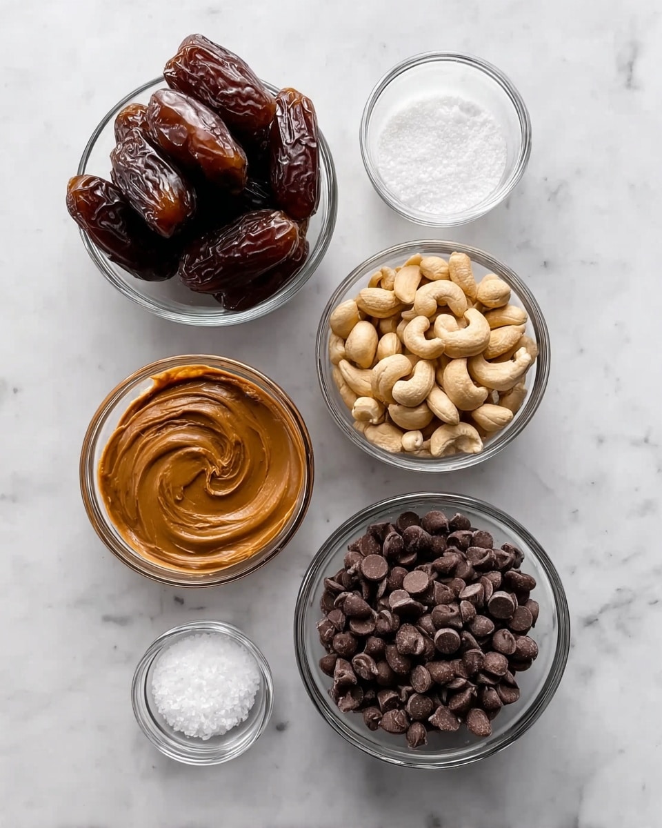 The image shows five clear glass bowls arranged on a white marbled surface. The top left bowl contains dark brown dates with a shiny and slightly wrinkled texture, stacked closely together. To the right, there is a smaller bowl filled with light beige cashew nuts that look smooth and curved. Below these, on the left, a bowl holds creamy, light brown peanut butter with a smooth swirl on its surface. Next to it, a larger bowl is filled with dark brown chocolate chips, uniform in size and shape, forming a dense layer. In the front, two small bowls sit side by side: one contains fine white salt crystals and the other holds a dollop of white solid coconut oil with a slightly rough texture. photo taken with an iphone --ar 4:5 --v 7