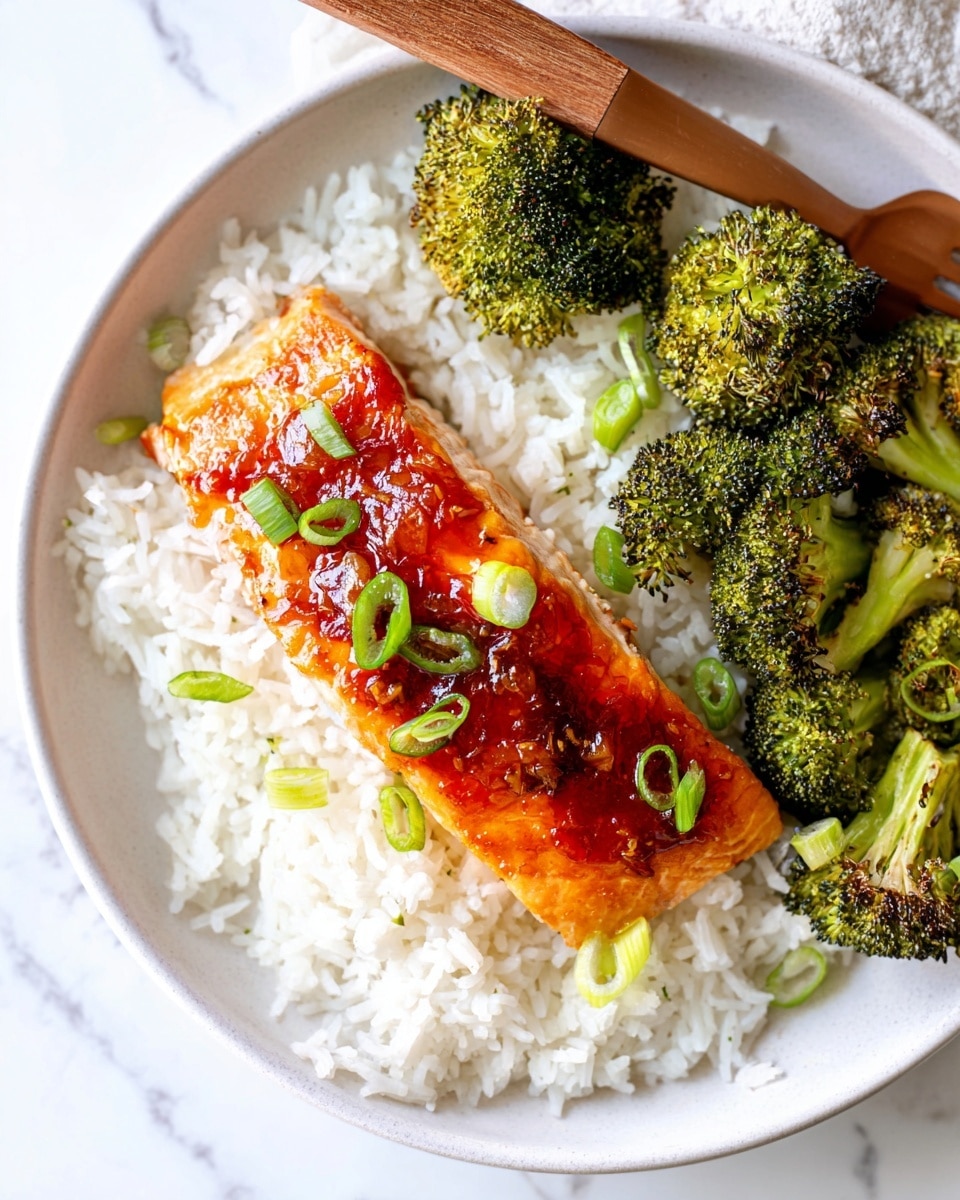 A white plate holds a layer of fluffy white rice as the base. On top, slightly to the left, there is a single piece of cooked salmon covered with a shiny, reddish-orange glaze and small green onion slices scattered over it. To the right side of the plate, bright green broccoli florets with lightly charred edges sit partially on the rice. A wooden fork rests at the upper left side of the plate, touching the rice. The plate is placed on a white marbled surface. photo taken with an iphone --ar 4:5 --v 7