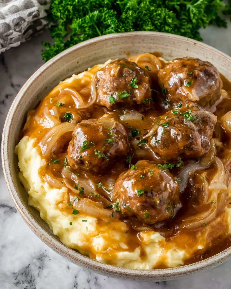 A round white bowl filled with three layers: the bottom layer is creamy pale yellow mashed potatoes with a smooth texture, the middle layer consists of gravy with sliced golden brown cooked onions mixed in, and the top layer features several medium-sized brown meatballs covered in thick, shiny brown gravy with a few small bits of green herbs sprinkled on top, all sitting on a white marbled surface with some green parsley in the background, photo taken with an iphone --ar 4:5 --v 7