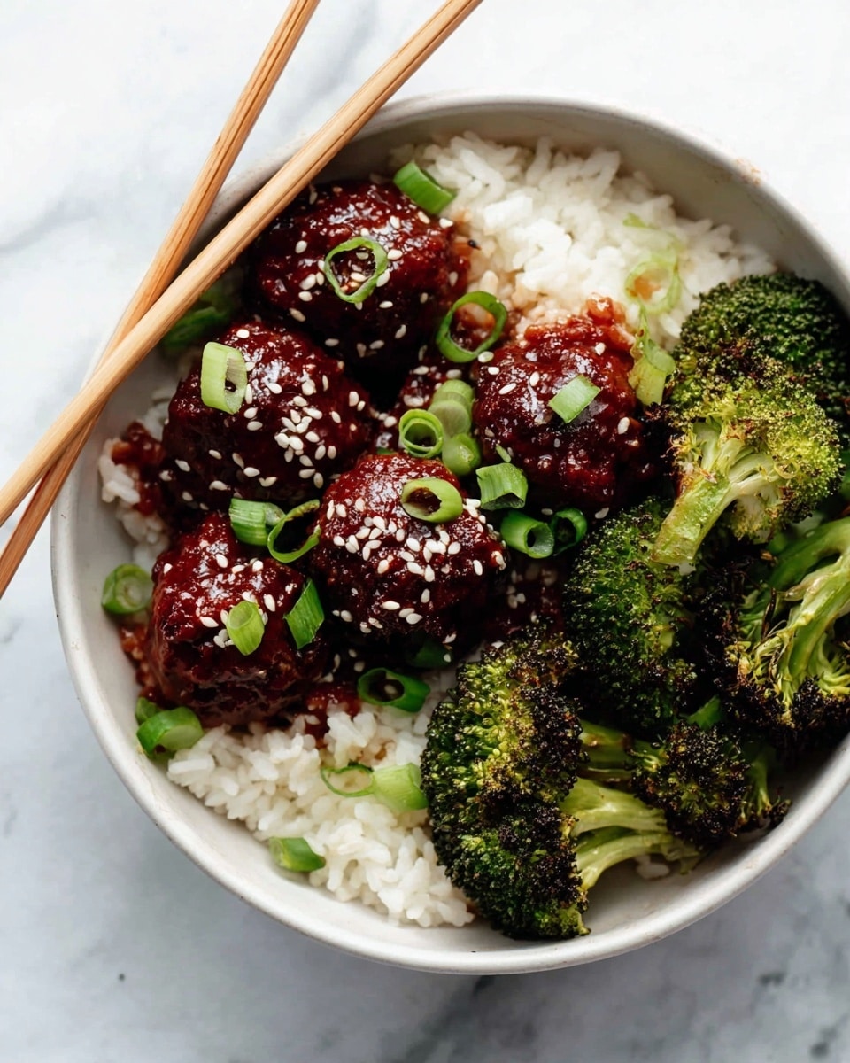 A white bowl holds a bed of fluffy white rice as the base layer, topped with several glossy, dark red meatballs covered in sesame seeds and garnished with sliced green onions. On one side of the bowl, there are vibrant green roasted broccoli florets with slightly charred edges, adding texture and color contrast. A pair of light brown chopsticks rest on the rice, angled into the bowl. The bowl sits on a white marbled surface. Photo taken with an iphone --ar 4:5 --v 7