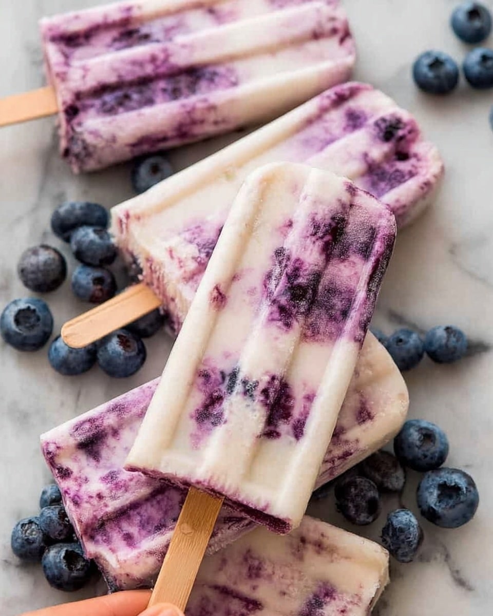 The image shows three creamy blueberry popsicles with a marbled mix of white and purple colors, with darker purple spots of blueberries spread throughout. The popsicles have a ridged texture and are arranged close together on a white marbled surface. One of the popsicles has a woman's hand holding its wooden stick, positioned in the center of the image, while fresh blueberries are scattered around them for decoration. photo taken with an iphone --ar 4:5 --v 7
