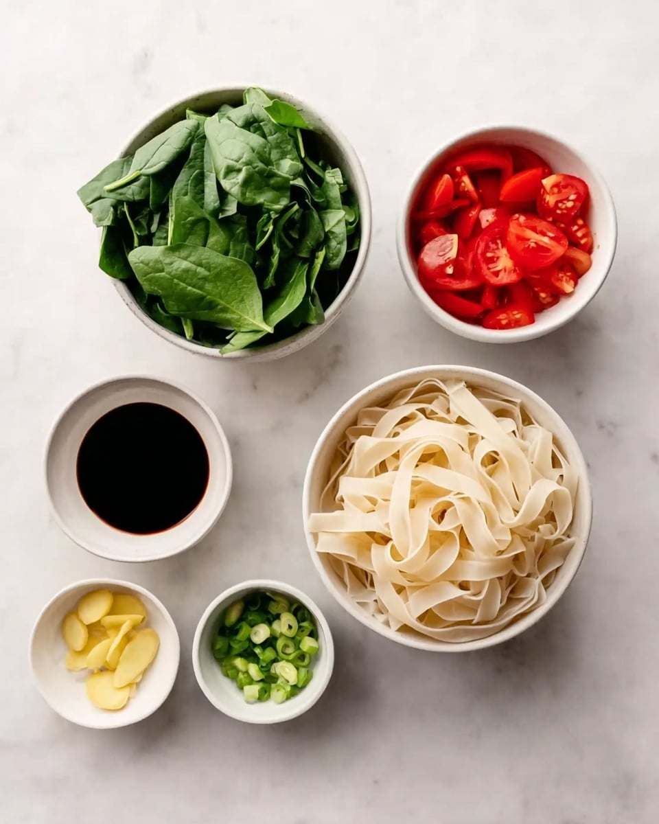 The image shows six white bowls arranged on a white marbled surface. The largest bowl at the bottom left holds fresh green spinach leaves. To its right is a medium white bowl filled with flat, wide rice noodles, slightly curled and piled up. Above the noodles is a small white bowl containing dark soy sauce. To the right of the soy sauce is a medium white bowl with bright red tomato pieces. Below the tomatoes, a smaller white bowl holds chopped green onions, and to its left is the smallest white bowl with thin slices of pale yellow ginger. photo taken with an iphone --ar 4:5 --v 7