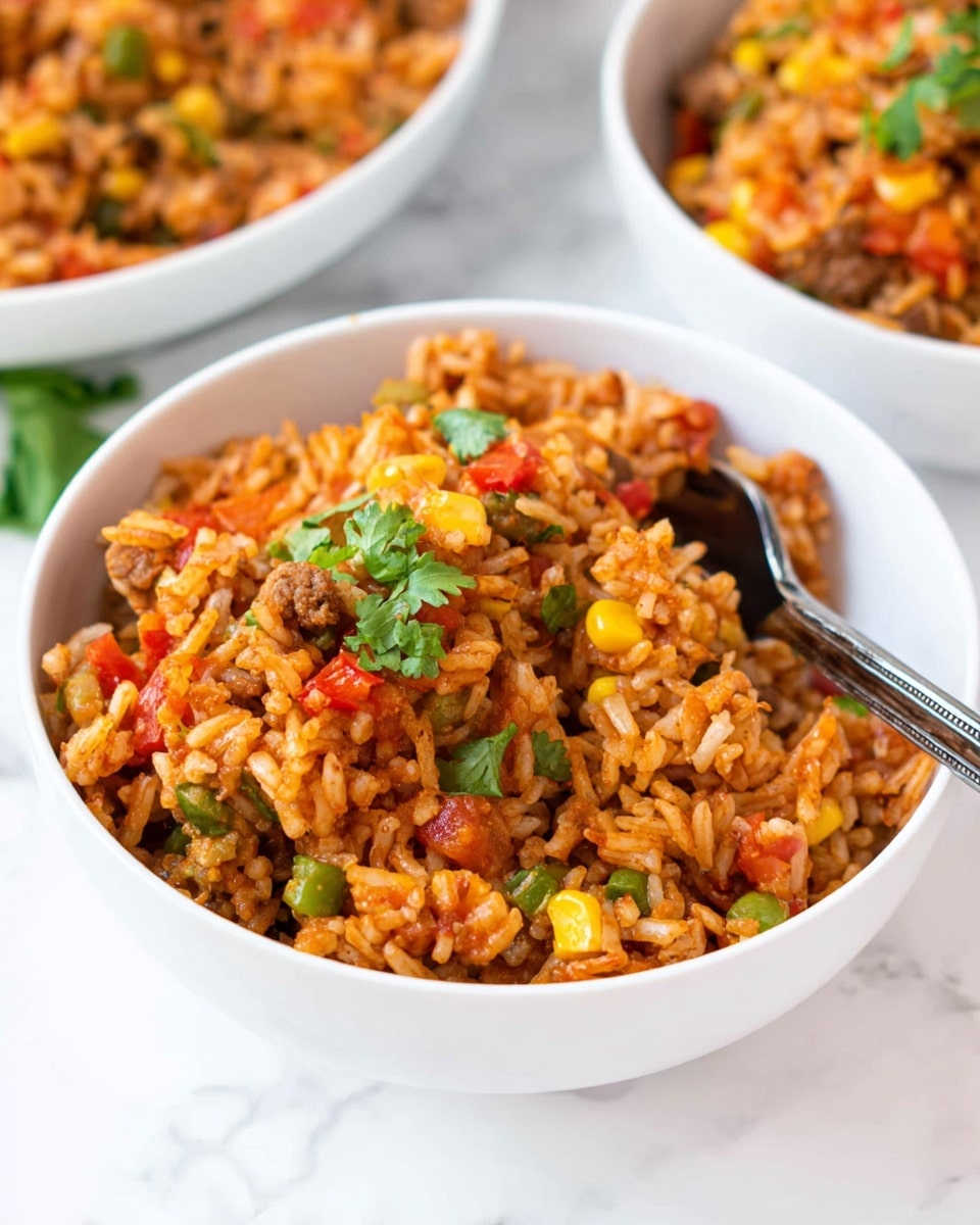 A white bowl filled with a colorful mix of rice, corn, diced red and green bell peppers, onions, and small pieces of cooked meat, all coated in a reddish seasoning. The dish has a soft texture with visible grains of rice and vegetable chunks, garnished with fresh green cilantro leaves on top. A metal fork is resting inside the bowl, ready to scoop up the meal. The bowl is placed on a white marbled surface, and other similar bowls with the same dish are seen slightly out of focus in the background. Photo taken with an iphone --ar 4:5 --v 7