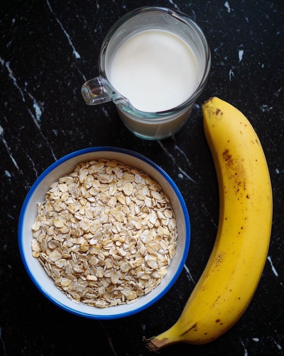 The image shows three simple breakfast ingredients placed on a black surface changed to a white marbled texture. There is a clear glass jug filled with white milk on the top left. Below it, a white bowl with a blue rim is filled with light beige rolled oats, forming one thick textured layer. To the right of the bowl, there is a whole yellow banana with some brown spots, resting beside it. photo taken with an iphone --ar 4:5 --v 7