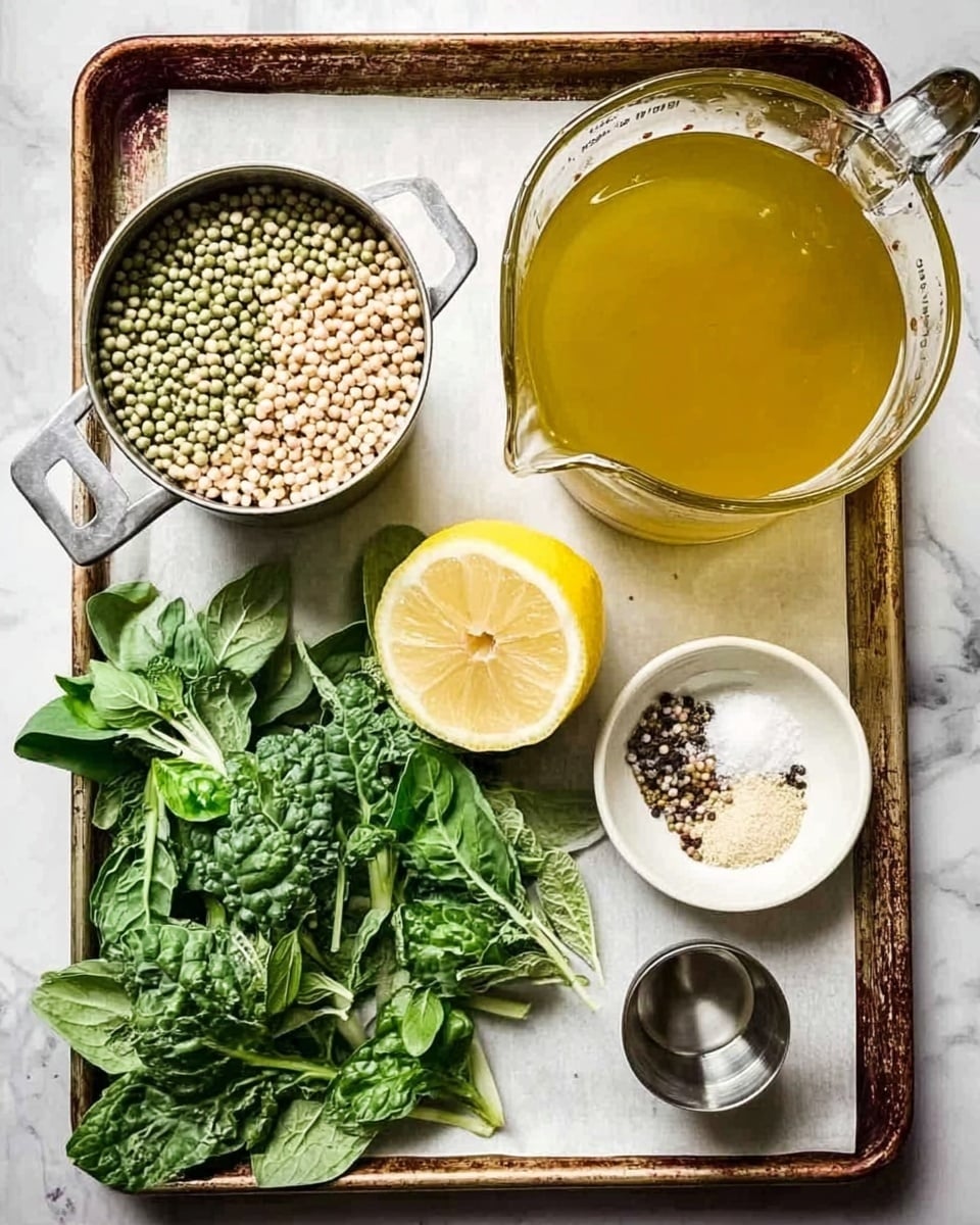 The image shows a baking tray with a white marbled surface beneath it, filled with fresh ingredients arranged neatly. On the top left, there is a small metal measuring cup filled with mixed dry pulses in pale green, light brown, and white colors, showing a grainy texture. To its right, a large glass measuring jug contains a golden-yellow liquid broth that is smooth and translucent. Below the pulses is a half lemon placed flat, revealing its bright yellow inside with visible juice sacs and white pith around it. In the center bottom area, several leafy green herbs with rich, fresh textures and varying shapes lay spread, their colors ranging from deep to bright green. On the bottom right, a small white bowl contains three different powders — fine white salt, pale yellow powder, and cracked black pepper — neatly separated in the bowl. Next to the bowl, a small silver cup with a shiny surface holds a small amount of clear yellow oil. The whole setup is clear, bright, and colorful with a clean white marbled background. photo taken with an iphone --ar 4:5 --v 7