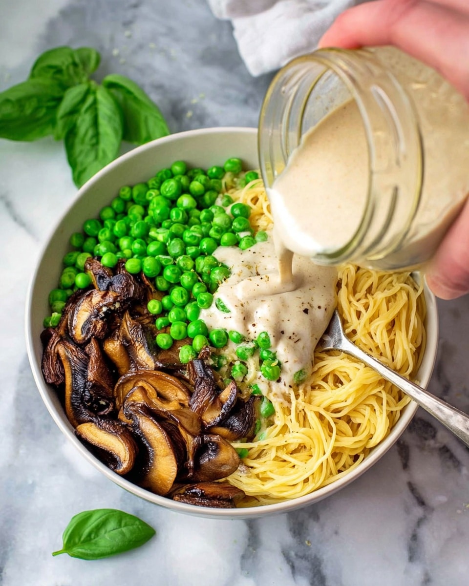 A clear glass jar with a silver metal lid holds a thick, creamy beige sauce. The sauce fills the jar almost to the top, with a smooth and slightly textured surface visible through the glass. In the background, uncooked yellow spaghetti is laid flat on a wooden cutting board, a bunch of fresh green basil leaves lies to the left, and blurred bowls with white mushrooms and green peas are behind the jar. All items rest on a white marbled surface, creating a clean and fresh kitchen scene. photo taken with an iphone --ar 4:5 --v 7